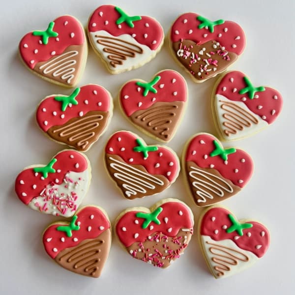 Several chocolate covered strawberries decorated sugar cookies
