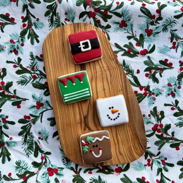 Mini sugar cookies decorated to look like Santa, an elf, a snowman and a gingerbread man